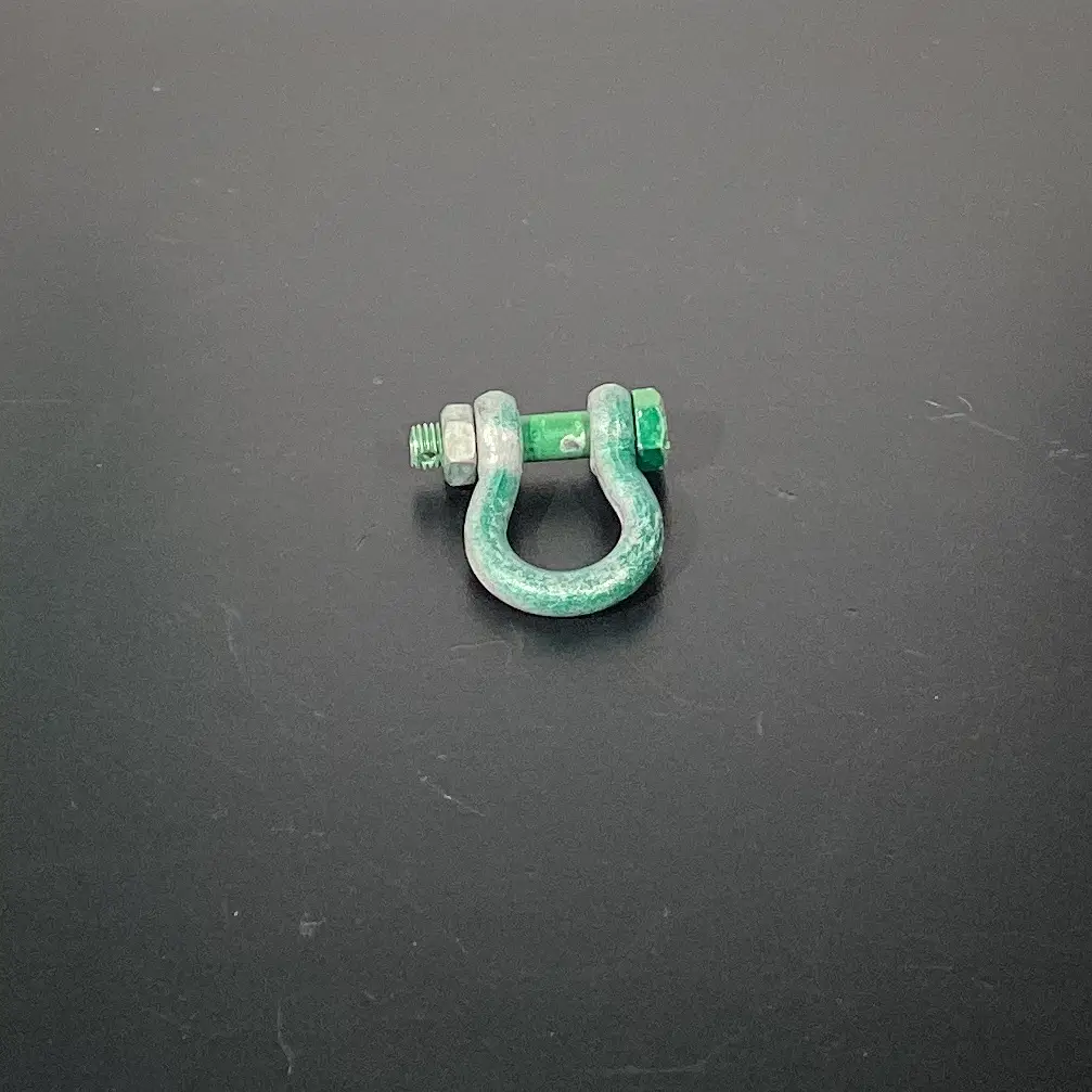 Lastverbinder aus Hamburg mieten: Der robuste Metall-D-Schäkel mit grünlicher Patina eignet sich perfekt für sichere Event-Aufbauten und professionelle Veranstaltungstechnik.