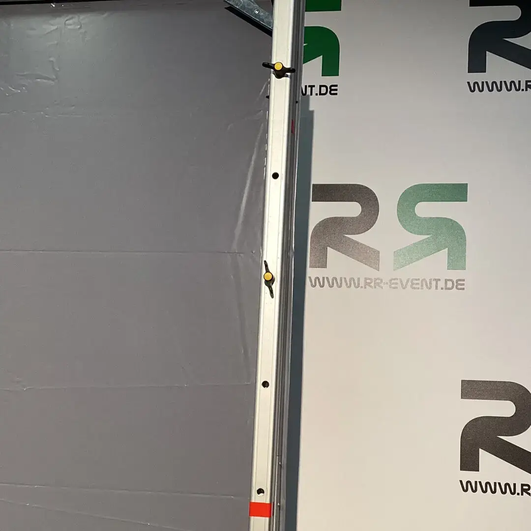 Das Produkt „Multimedialeinwand aus Brake“ wird professionell zwischen einem grauen Hintergrund und einem Banner mit Ihrem Logo präsentiert – ideal, um Ihre Veranstaltung durch den Verleih moderner, hochwertiger Technik optimal in Szene zu setzen.